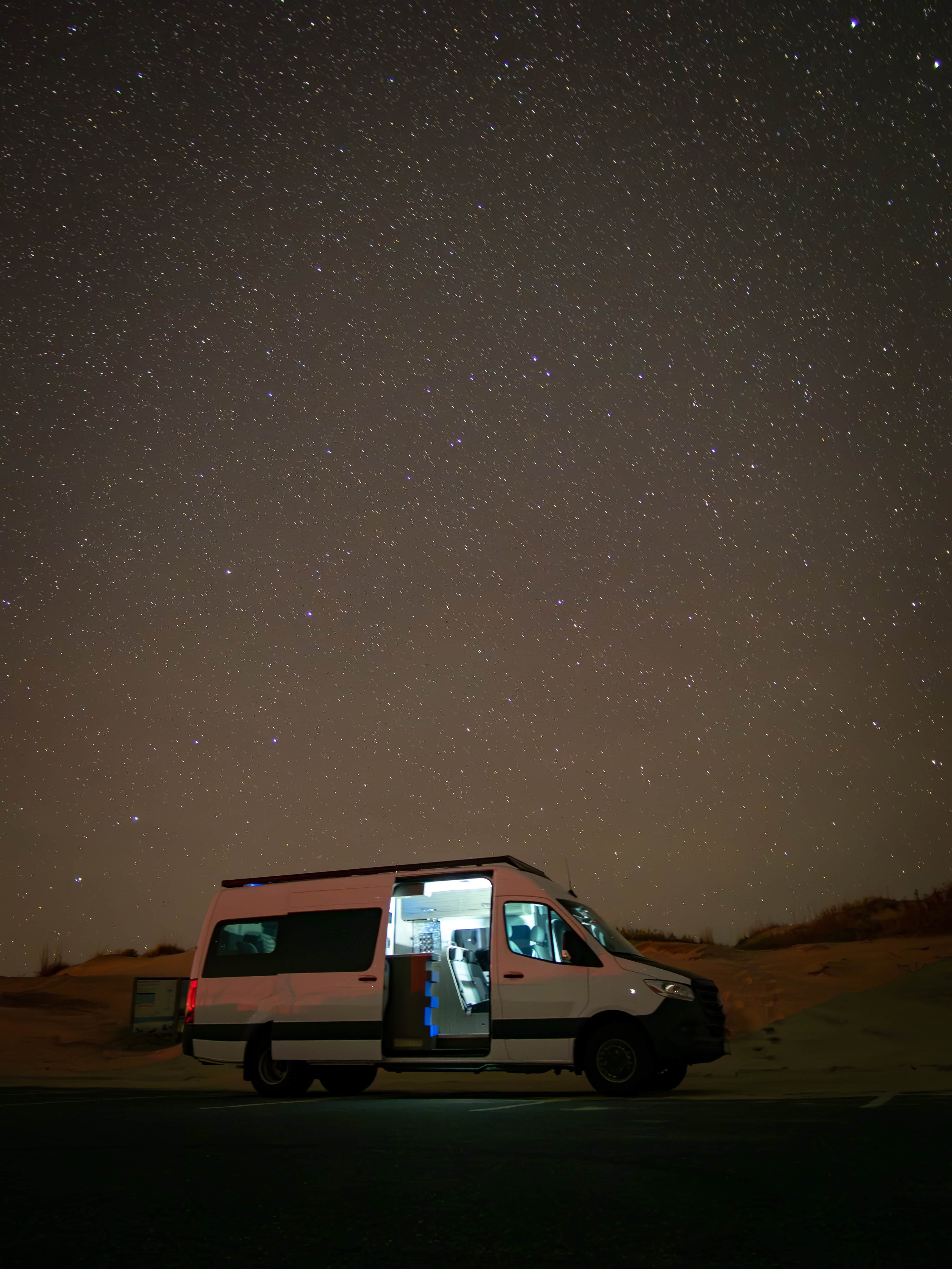 Icon Vans fourgon aménagé with doors open under a starry desert night sky