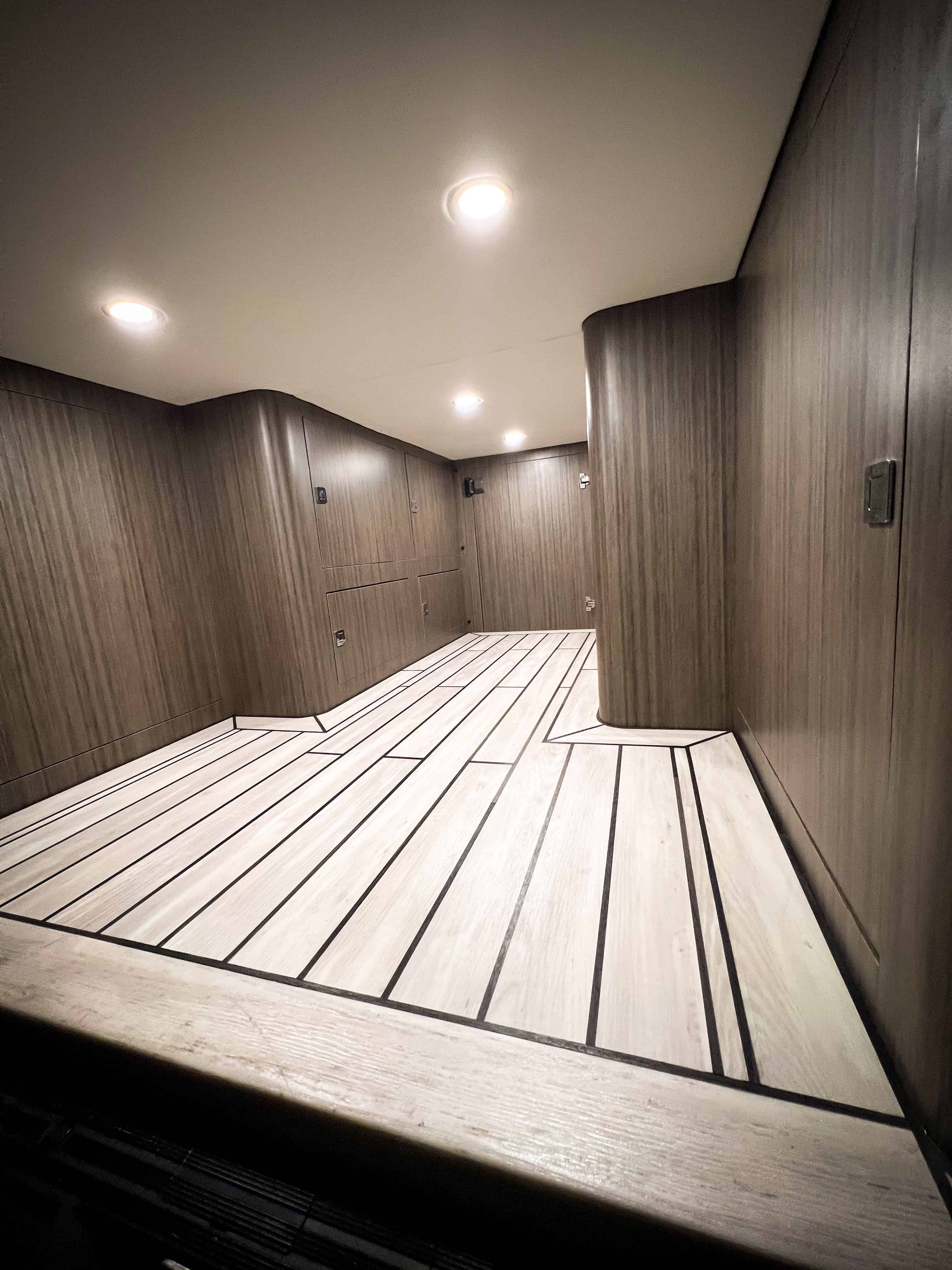 Interior cargo bay of fourgon aménagé with wood-grain finish and marine-inspired plancher